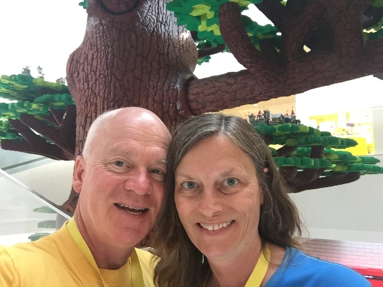 Gail and Paul beneath the Tree of Creativity at Lego House Lego Inside Tour