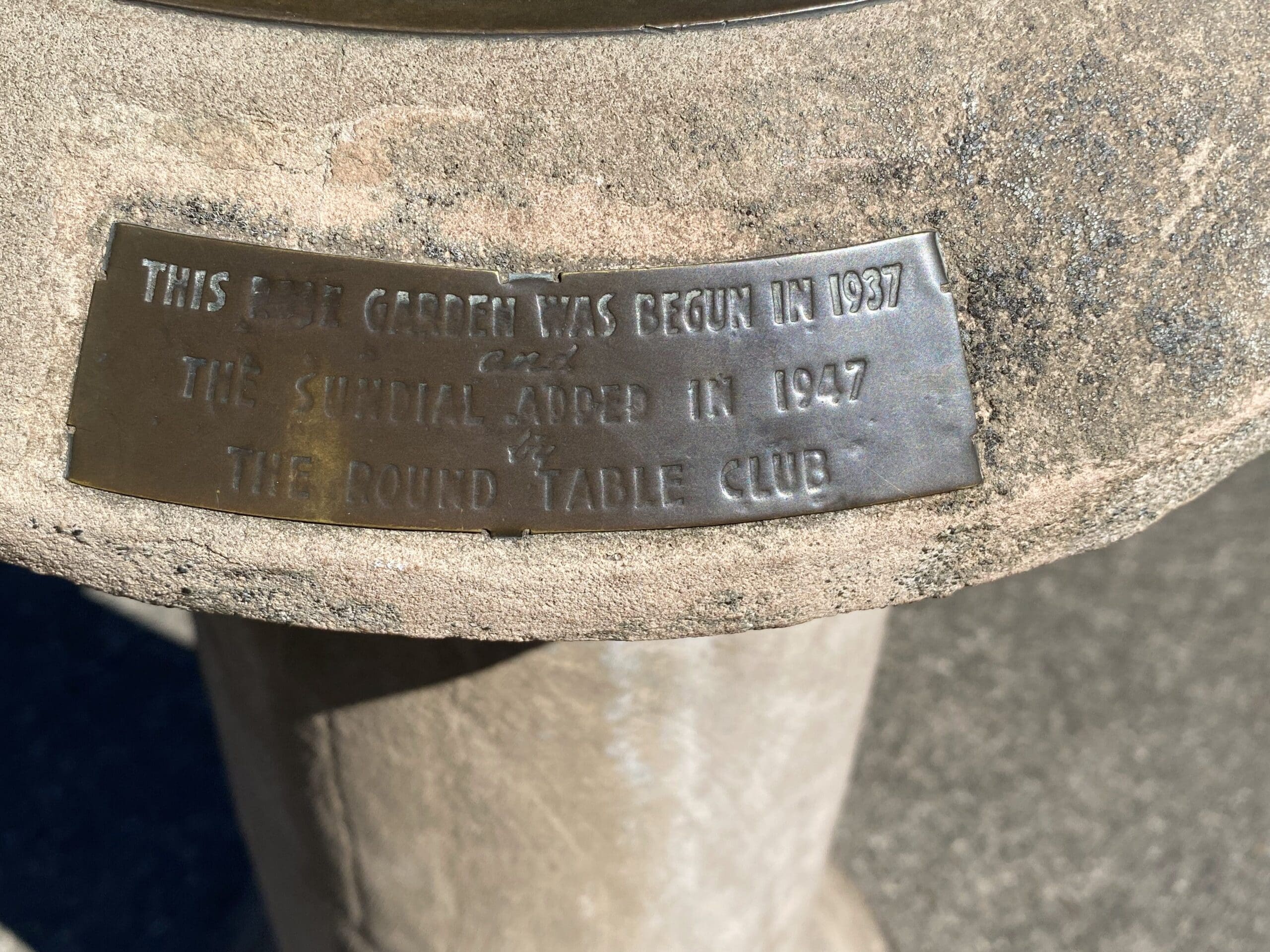 Plaque on sun dial which reads "This East Garden was begun in 1937 and the Sundial added in 1947 by The Round Table Club"